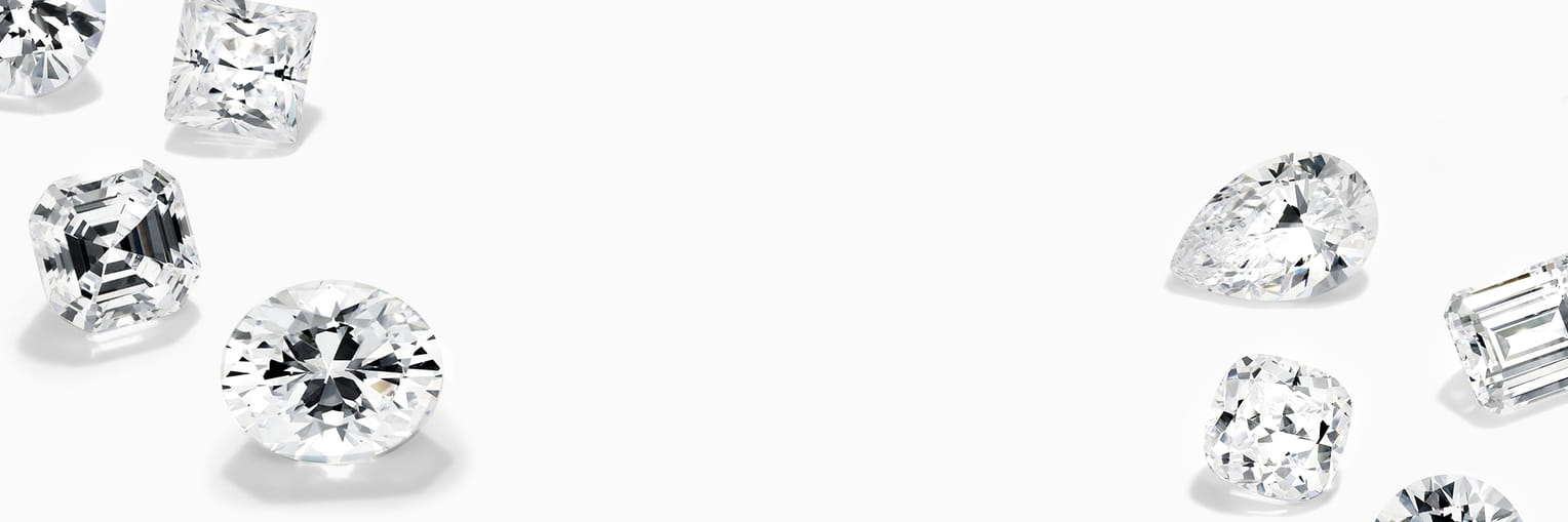 Various shapes of sparkling cut diamonds arranged on a white background."