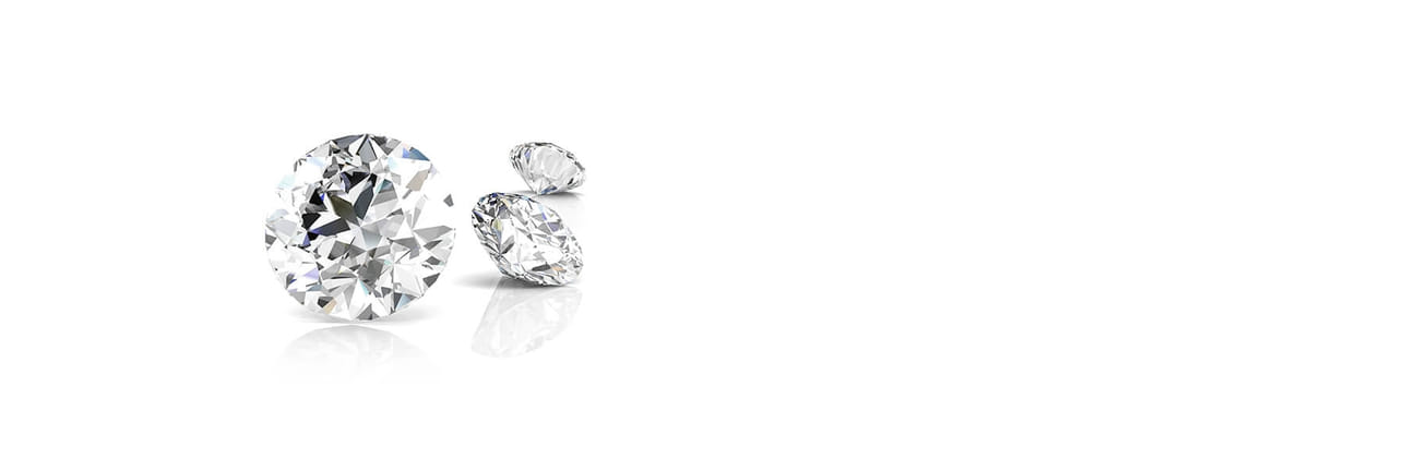 Collection of sparkling, clear-cut diamonds reflecting light on a white background."