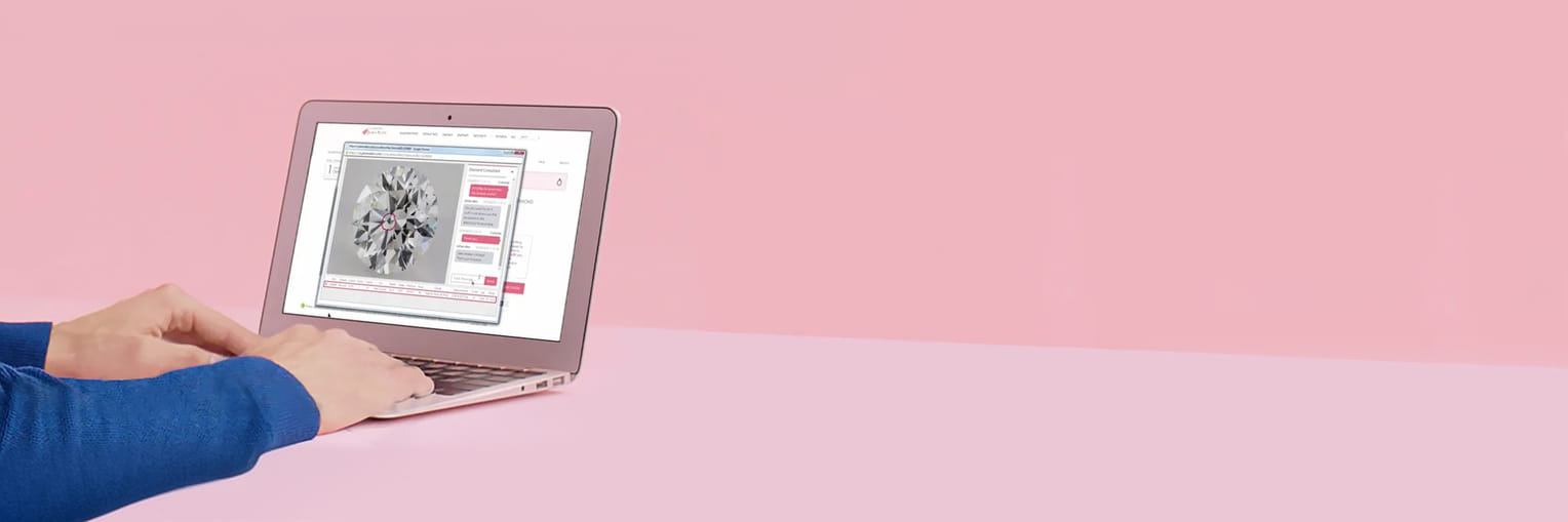 Person using laptop with diamond software on a pink background.