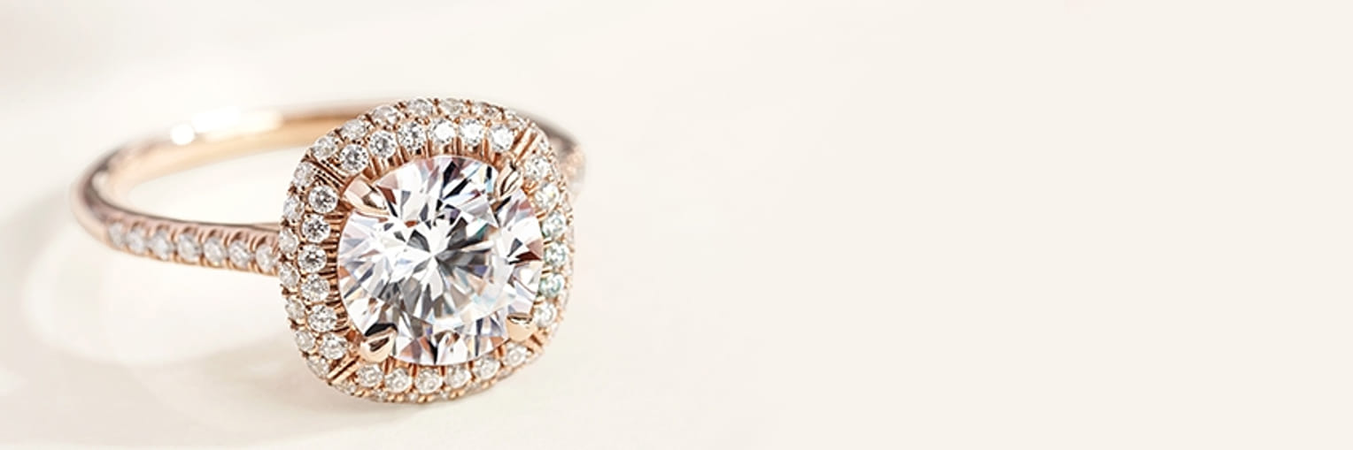 Elegant diamond ring with intricate design displayed on a light background.